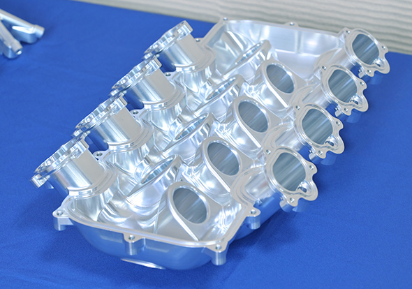 An automotive intake manifold (sample workpiece) finished by simultaneous five-axis machining from both directions on cylindrical sections using 5-Axis Auto Tuning System Ⅱ